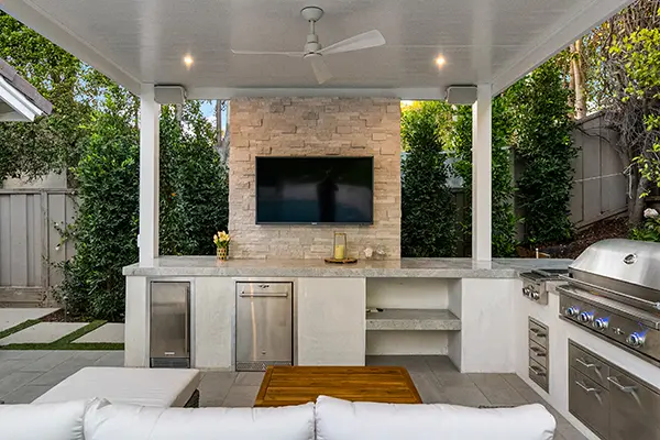 Outdoor Living Kitchen Area with Stone Backdrop Wall & TV